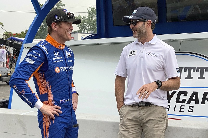 Six-time IndyCar champion Scott Dixon, left, chats with Chip Ganassi Racing teammate Jimmie Johnson before the start of practice of the IndyCar auto race, Friday, Aug. 6, 2021, in Nashville, Tenn. (AP Photo/Dan Gelston)