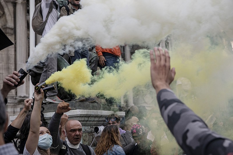 Protesters hold flares during a protest against the vaccine and vaccine passports, in Paris, France, Saturday Aug. 7, 2021. Some thousands of people are expected to march in Paris and other French cities on Saturday to protest against a special virus pass and what they see as restrictions of personal freedoms. (AP Photo / Adrienne Surprenant)