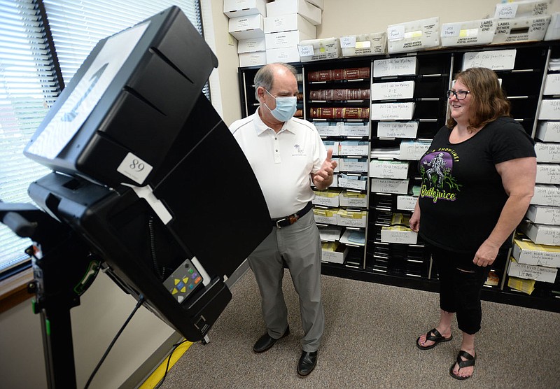 Jack Butt (left) of Fayetteville receives instructions Friday, Aug. 6, 2021, from Jamie Williams, assistant election administrator, before voting in the Washington County Clerk&#x221a;&#xef;s office in with county courthouse Fayetteville. Fayetteville voters will be asked to continue the city&#x221a;&#xef;s 1-cent sales tax for operations and some capital expenditures during a special election Tuesday. Visit nwaonline.com/210808Daily/ for today's photo gallery.
(NWA Democrat-Gazette/Andy Shupe)