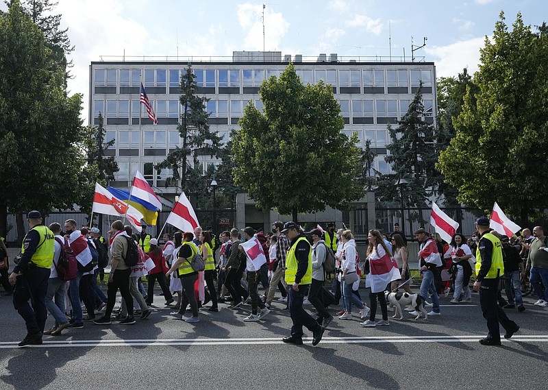 Protesters carrying the white-and-red banner of the Belarusian opposition march past the U.S. Embassy in Warsaw, Poland, on Sunday, Aug. 8, 2021. Hundreds of people, among them many Belarusians living in exile in Poland, marched in Warsaw to protest political repression in Belarus, a manifestation held on the eve of the one-year anniversary of the presidential election they consider stolen. They called on foreign powers to declare the Belarusian regime a terrorist organization. (AP Photo/Czarek Sokolowski)