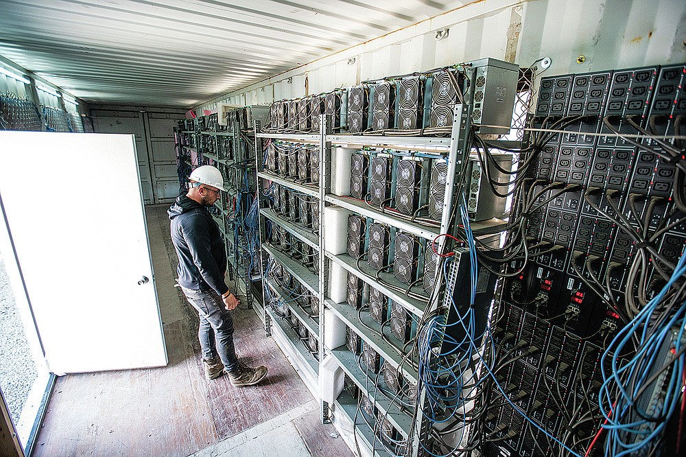 Chris Radwanski, data center supervisor, checks on bitcoin mining machines in a shipping container behind the Scrubgrass Power plant on Friday, July 23, 2021, in Russellton, Pa. (Andrew Rush/Pittsburgh Post-Gazette via AP)