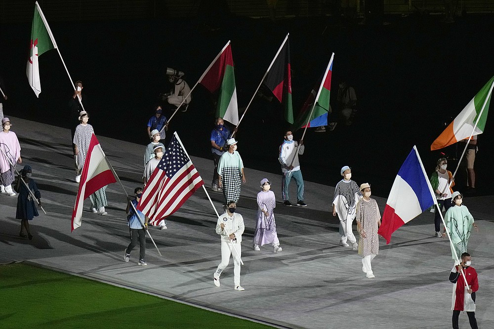 Kara Winger, of the United States of America, center, arrives to the closing ceremony in the Olympic Stadium at the 2020 Summer Olympics, Sunday, Aug. 8, 2021, in Tokyo, Japan. (AP Photo/Hassan Ammar)