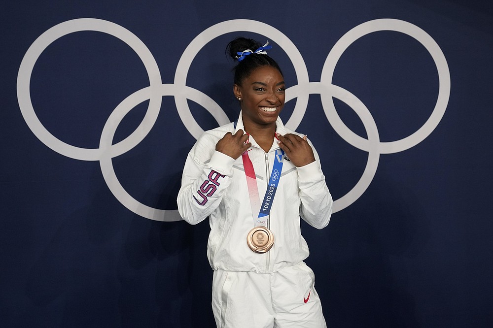 Simone Biles, of the United States, poses wearing her bronze medal from balance beam competition during artistic gymnastics at the 2020 Summer Olympics, Tuesday, Aug. 3, 2021, in Tokyo, Japan. (AP Photo/Natacha Pisarenko)
