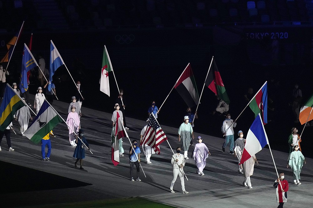 Kara Winger, of the United States of America, center, and other flags are carried in during the closing ceremony in the Olympic Stadium at the 2020 Summer Olympics, Sunday, Aug. 8, 2021, in Tokyo, Japan. (AP Photo/Hassan Ammar)