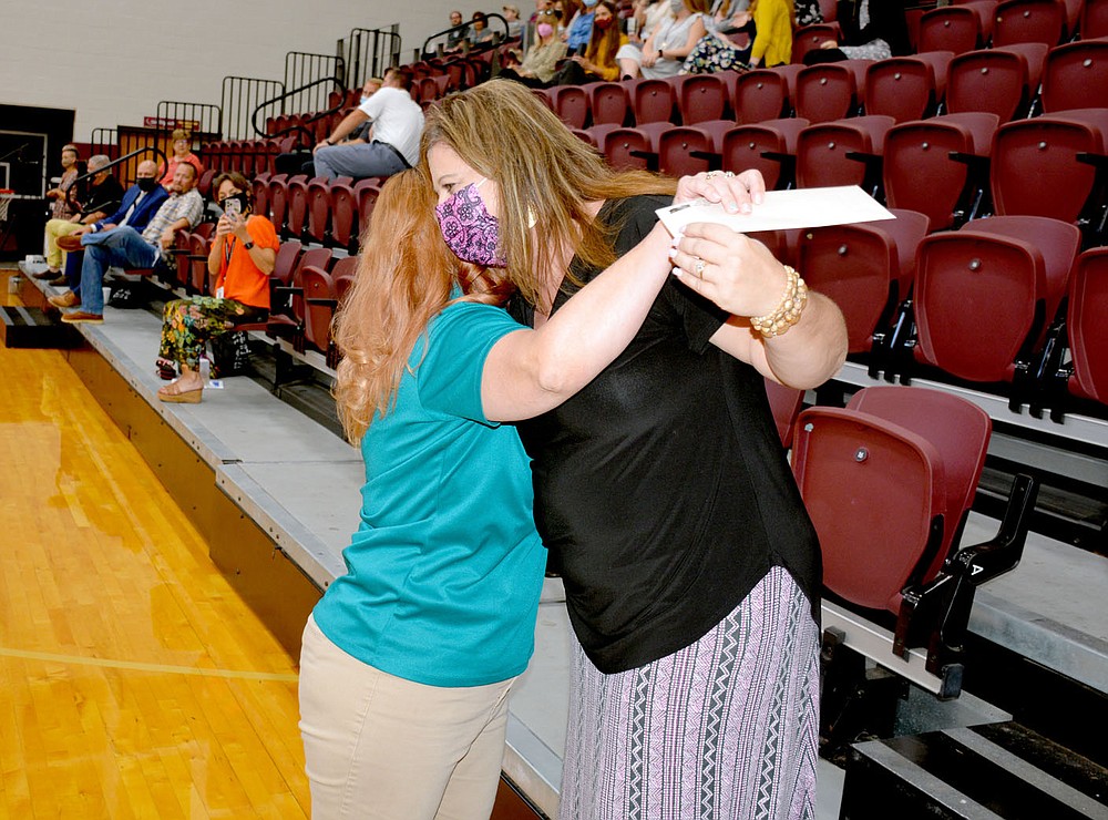 Marc Hayot/Siloam Sunday Northside Assistant Principal Brandy Fox (right), hugs Patti Eiland after receiving $500 as a door prize at the Back to School Breakfast on Wednesday at the high school. The prize money was donated by Dr. Van Dyck Dentistry.