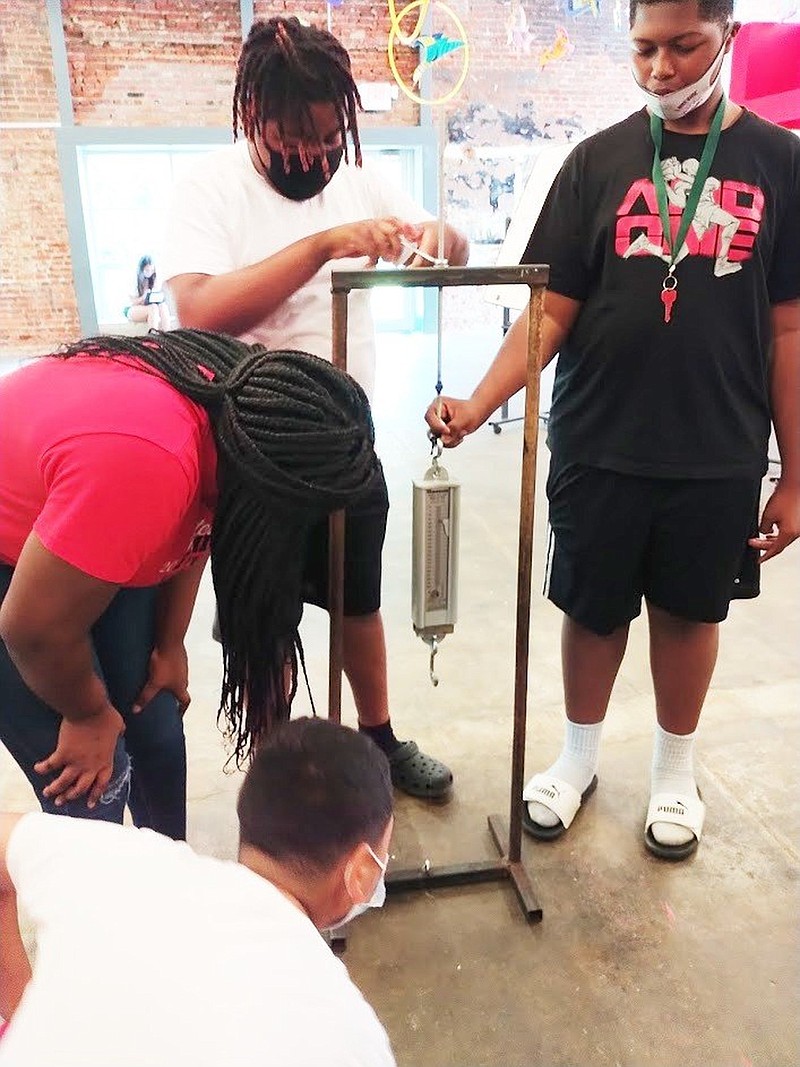 Eric Mondragon, bottom left, Makayla McBride, Elijah Stanton and Jaiden Washington, all of Eudora, experiment with testing the pressure, time and measurement of a weight?s capacity and impact. (Special to The Commercial)