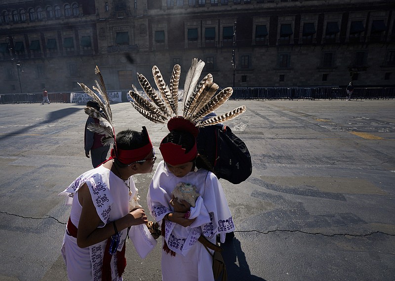 Two young dancers speak prior a performance as part of the commemoration marking the 700 year anniversary of the founding of the Aztec city of Tenochtitlan, known today as Mexico City, at Zocalo square in Mexico City on July 26 amid the new coronavirus pandemic. - AP Photo/Fernando Llano