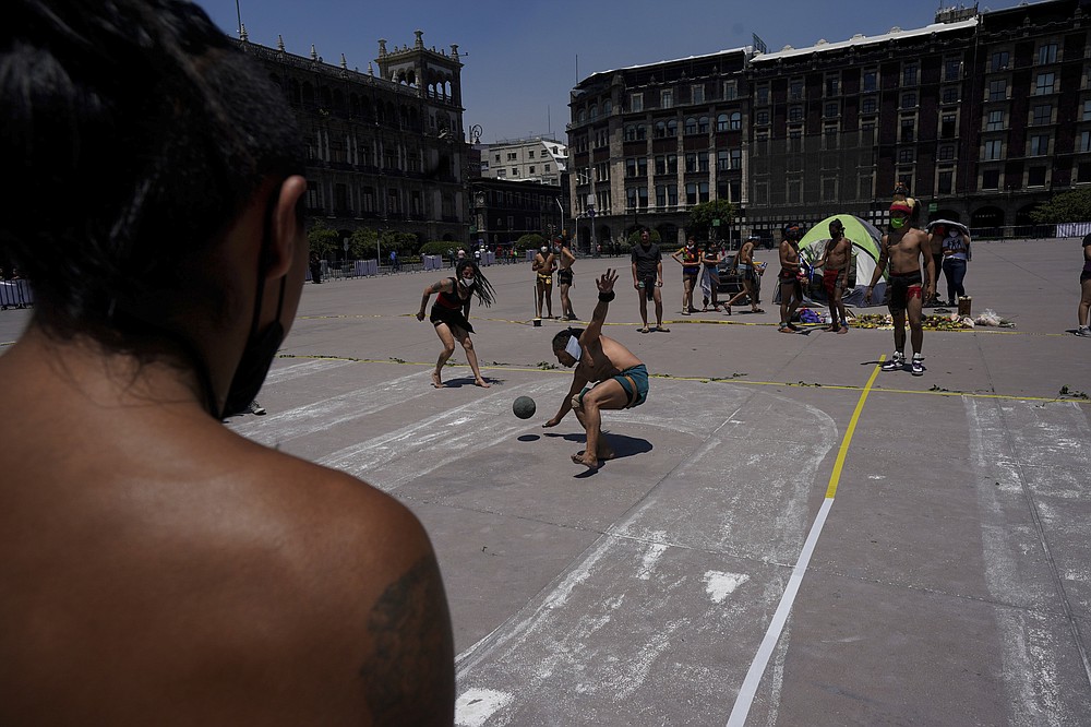 Dancers play "Pelota" during a performance as part of the commemoration marking the 700 year anniversary of the founding of the Aztec city of Tenochtitlan, known today as Mexico City, at the Zocalo square in Mexico City, Monday, July 26, 2021, amid the new coronavirus pandemic. (AP Photo/Fernando Llano)