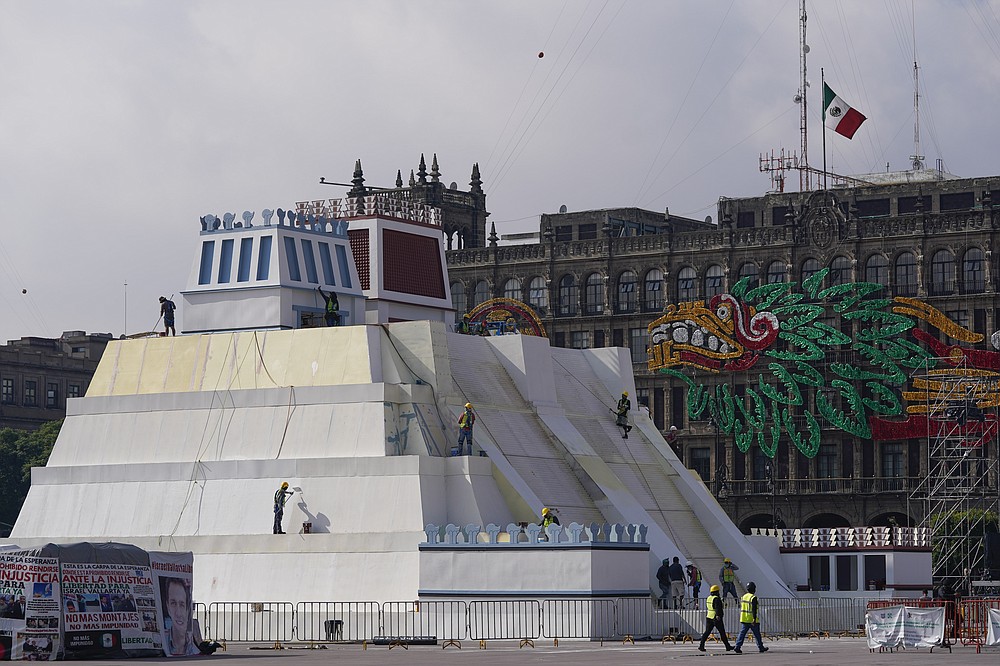 Workers build a replica of the Aztec Templo Mayor, with an image of the Pre-columbian god Quetzalcoatl adorning the surrounding buildings, at Mexico City's main square the Zocalo, Monday, Aug. 9, 2021. Mexico City is preparing for the 500 anniversary of the fall of the Aztec capital of Tenochtitlan, today's Mexico City, on Aug. 13, 2021. (AP Photo/Eduardo Verdugo)