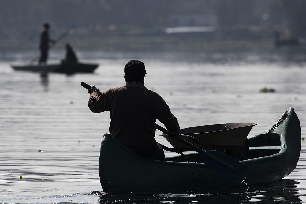 A farmer carries a wheelbarrow in his canoe as e paddles to his farm known as "chinampa," in Xochimilco, in Mexico City, Thursday, Aug. 12, 2021, as Mexico City prepares for the 500th anniversary of the fall of the Aztec capital of Tenochtitlan. The canals and floating gardens of Xochimilco are the last remnants of a vast water transport system built by the Aztecs to serve their capital of Tenochtitlán. (AP Photo /Marco Ugarte)
