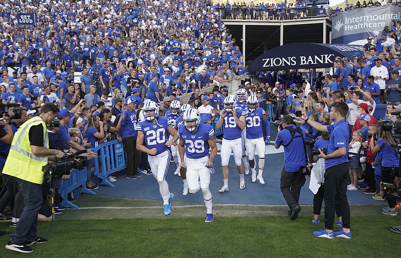 FILE - BYU football players enter the field to warm up for an NCAA college football game against Utah in Provo, Utah, in this Thursday, Aug. 29, 2019, file photo. A deal BYU has made available to its football players could test how much allowing athletes to be compensated by outside companies for name, image and likeness can be used as a competitive advantage. On Thursday, Aug. 12, 2021, BYU announced Built Brands &#x2014;- a Utah-based company that makes protein-heavy snacks &#x2014;- will give the opportunity for all 123 members of its football team to be paid to promote its products. (AP Photo/George Frey, File)