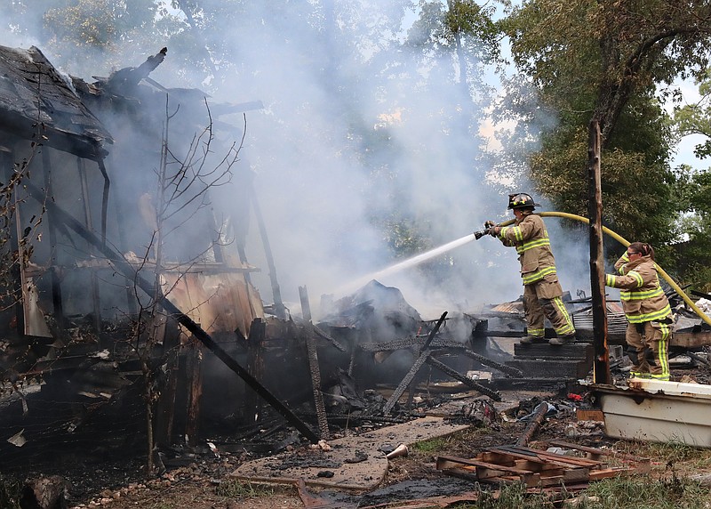 Volunteers from 70 West Fire Department fight a fire in a single-wide mobile home at 193 Graves Trail Monday. - Photo by Richard Rasmussen of The Sentinel-Record