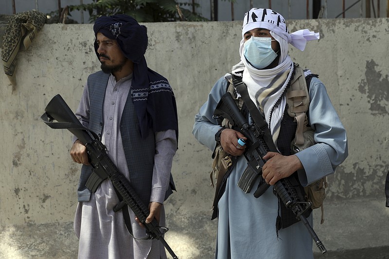 Taliban fighters stand guard in the main gate leading to Afghan presidential palace, in Kabul, Afghanistan, Monday, Aug. 16, 2021. The U.S. military struggled to manage a chaotic evacuation from Afghanistan on Monday as the Taliban patrolled the capital and tried to project calm after toppling the Western-backed government. (AP Photo/Rahmat Gul)