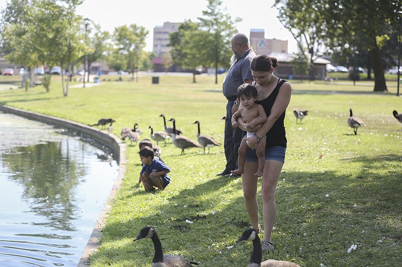 Brenda Moon (right) carries Victor Rico Moon, 1, as they walk around a pond, Monday, August 16, 2021 at Murphy Park in Springdale. The Springdale council will consider making a smoking ban at Springdale parks. Check out nwaonline.com/210817Daily/ for today's photo gallery. 
(NWA Democrat-Gazette/Charlie Kaijo)