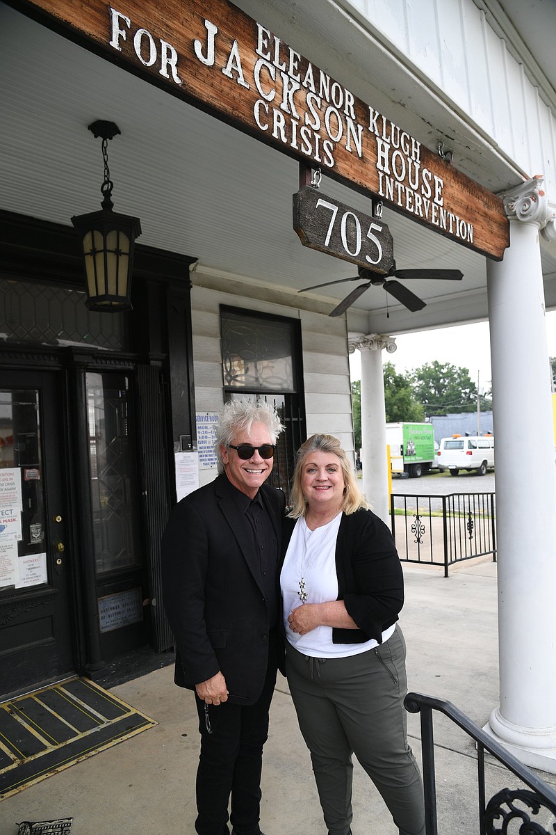 Magician Maxwell Blade, left, who is celebrating 25 years of entertaining Hot Springs, recently donated around $1,500 to Jackson House, which was accepted by Executive Director Janie Smith, who is shown with Blade on the front porch of the crisis intervention center. - Photo by Tanner Newton of The Sentinel-Record