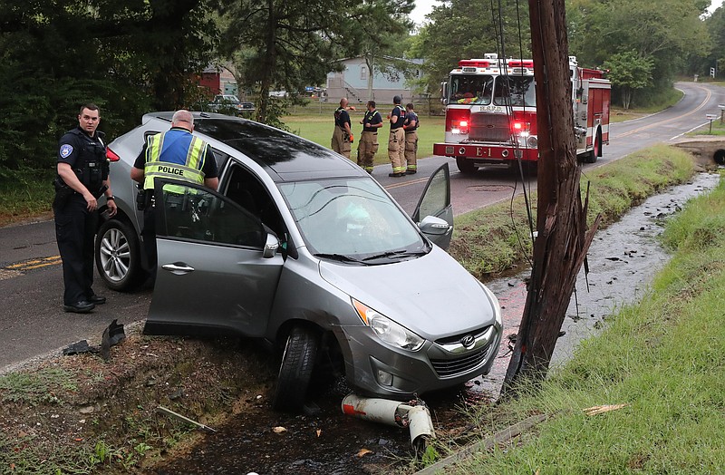 Hot Springs police and fire department personnel work the scene of a one-vehicle wreck in the 500 block of Millcreek Road on Wednesday. - Photo by Richard Rasmussen of The Sentinel-Record