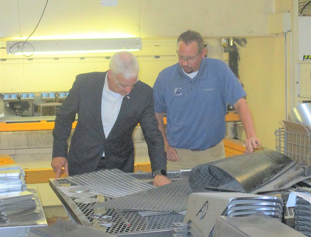 Marc Hayot/Siloam Sunday U.S Representative Stephen Womack (AR-3, left), and Alternative Design President/CEO Grant Loyd inspect some of the metal pieces used to manufacture products at Alternative Design on Wednesday. Womack, who has been visiting different small businesses in Northwest Arkansas stopped by Alternative Design and spoke with Loyd and other members of Alternative Design's leadership.