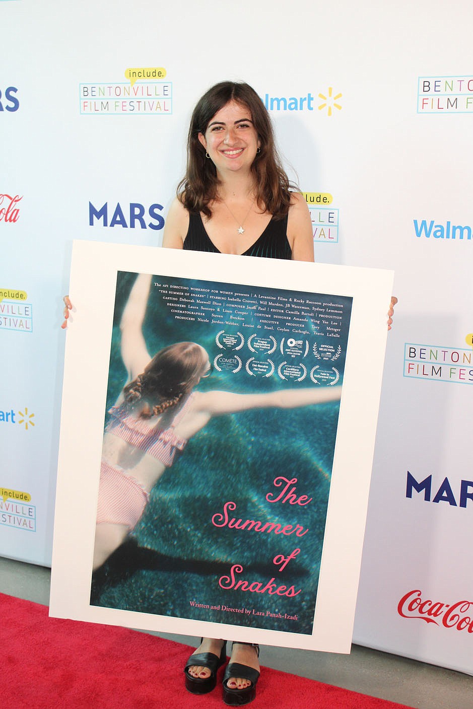 Director Lara Panah-Izadi stands with a poster of her Bentonville Film Festival entry, "The Summer of Snakes."
(NWA Democrat-Gazette/Carin Schoppmeyer)