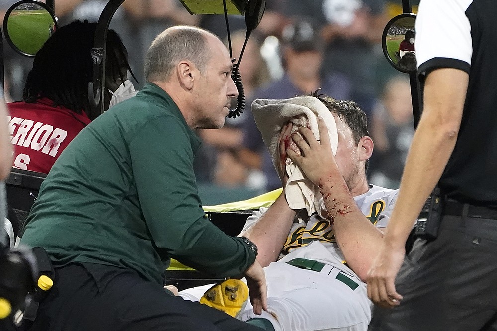 Oakland Athletics starting pitcher Chris Bassitt is taken off the field after getting hit in the head from a ball hit by Chicago White Sox's Brian Goodwin during the second inning of a baseball game, Tuesday, Aug. 17, 2021, in Chicago. (AP Photo/Charles Rex Arbogast)