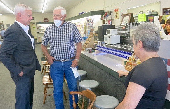 Westside Eagle Observer/SUSAN HOLLAND
Paulette Austin looks on as Congressman Steve Womack visits with area realtor and rancher Vernon Schmiegelow Wednesday, August 18, at Austin Drug. Womack began his Small Business Tour of Gravette at the drugstore, then visited other local businesses.