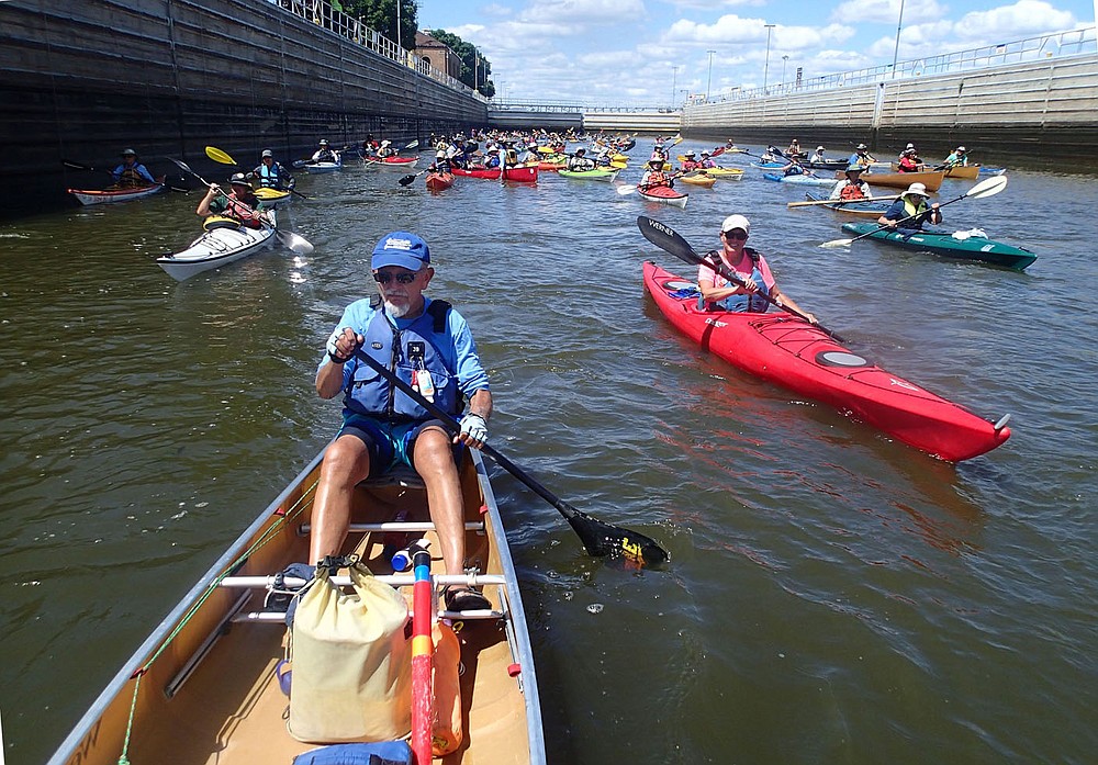 Paddlers including J.B. Livengood (foreground) of Illinois exit a lock Aug. 2 2021 at Bellevue, Iowa. The whole flotilla, some 200 canoes and kayaks, enters and exits the lock as a group. Paddlers locked through three locks and dams on the trip.
(NWA Democrat-Gazette/Flip Putthoff)
