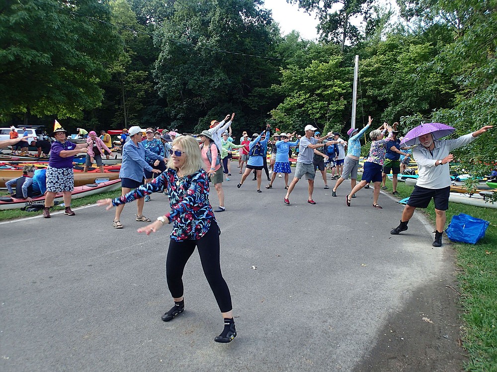 Mary Jo Shear leads stretching exercises each morning for any paddlers who want to limber up for their day on the water.
(NWA Democrat-Gazette/Flip Putthoff)