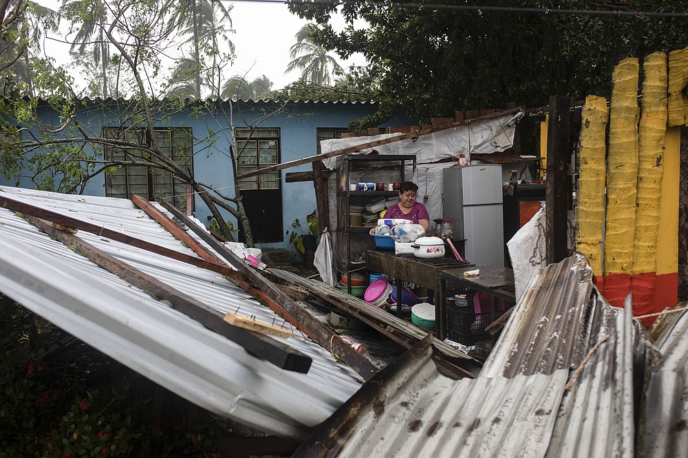 A woman begins clearing debris from her kitchen after a part of her home was damaged by winds brought on by Hurricane Grace, in Tecolutla, Veracruz State, Mexico, Saturday, Aug. 21, 2021. Grace hit Mexico&#x2019;s Gulf shore as a major Category 3 storm before weakening on Saturday, drenching coastal and inland areas in its second landfall in the country in two days. (AP Photo/Felix Marquez)