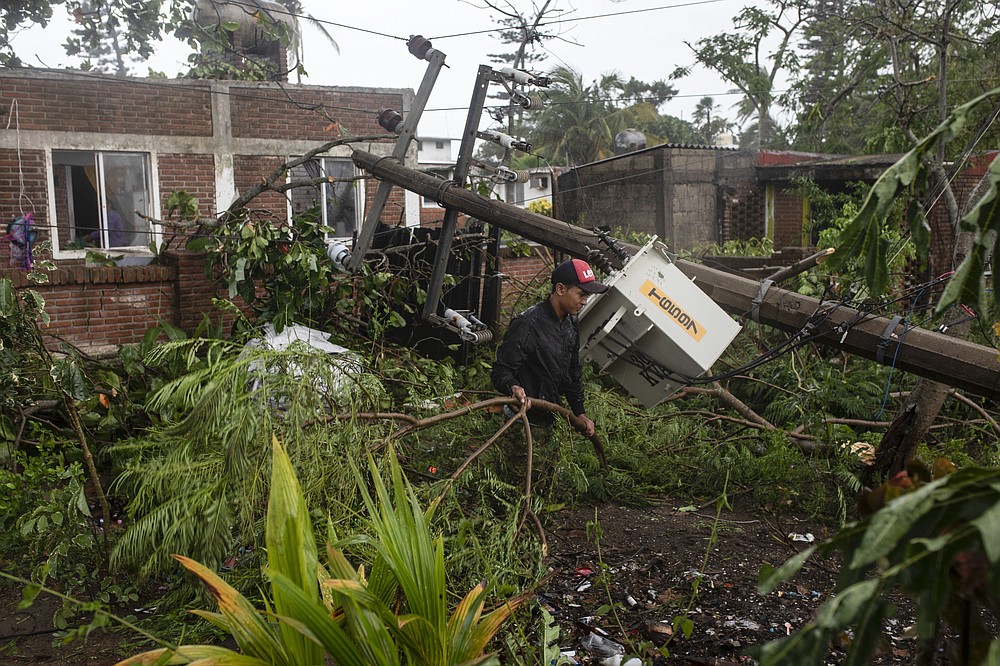 A man inspects the damage after part of his home was toppled by winds brought on by Hurricane Grace, in Tecolutla, Veracruz State, Mexico, Saturday, Aug. 21, 2021. Grace hit Mexico&#x2019;s Gulf shore as a major Category 3 storm before weakening on Saturday, drenching coastal and inland areas in its second landfall in the country in two days. (AP Photo/Felix Marquez)