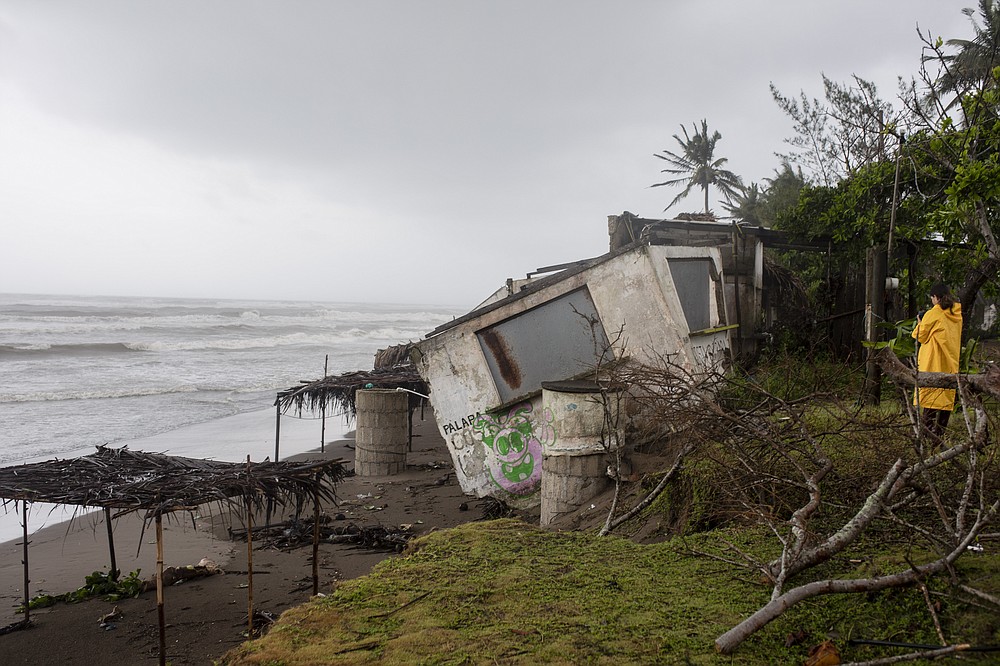 A journalist takes pictures of a damaged house that was damaged by winds brought on by Hurricane Grace, in Tecolutla, Veracruz State, Mexico, Saturday, Aug. 21, 2021. Grace hit Mexico&#x2019;s Gulf shore as a major Category 3 storm before weakening on Saturday, drenching coastal and inland areas in its second landfall in the country in two days. (AP Photo/Felix Marquez)