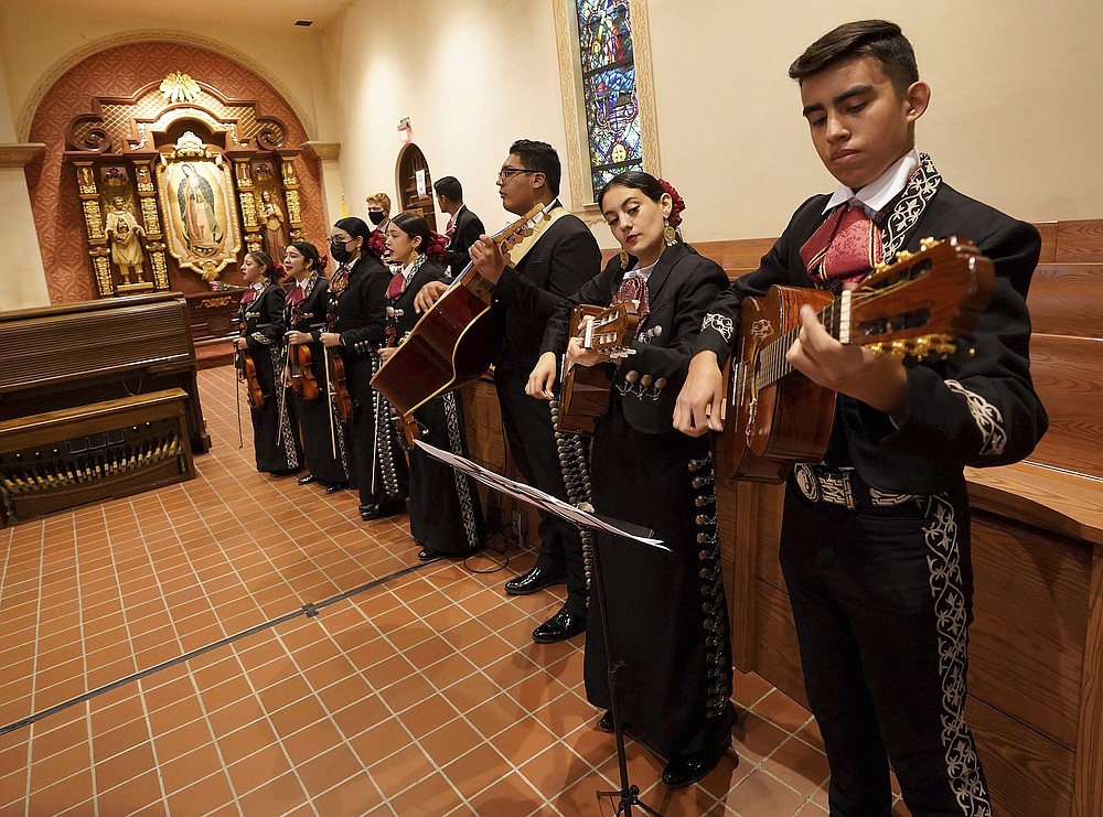 The Los Changuitos Feos (Ugly Little Monkeys) mariachi band prepare for parishioners during an early morning mass at St. Augustine's Cathedral on Sunday, August 18, 2021 in downtown Tucson.  While mariachi is a popular genre at its core, musicians and parishioners say its emotional interplay between trumpet, violin, guitar, vihuela, and guitarrÃ³n is a natural complement to the sacred rites of Mass.  (AP Photo / Darryl Webb)