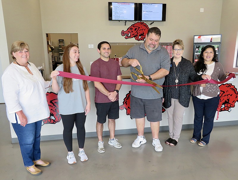 Westside Eagle Observer/RANDY MOLL
Manager Dennis Boling, accompanied by employees Halle Reid and Ryan Duffy, and Gentry Chamber of Commerce members Janie Parks, Andrea Tunn and Kristi Halloway, cuts the ribbon Thursday on the new Jim's Razorback Pizza, located at 884 S. Gentry Blvd., in Gentry. The new business is open from 11 a.m. until 9 p.m. every day. Customers can dine in or carry out, and delivery service is also available. The business phone number is 479-525-2022.