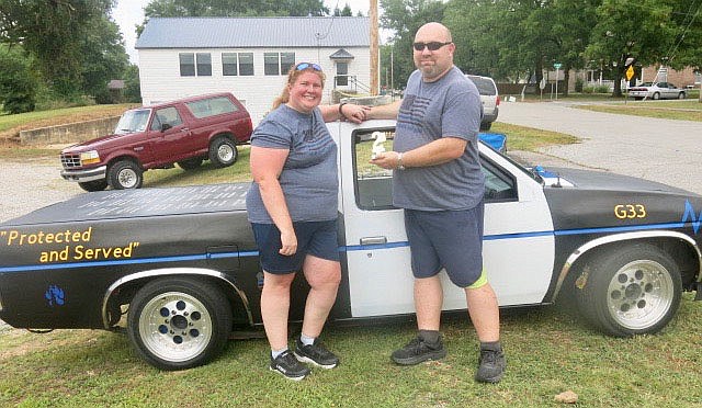 Westside Eagle Observer/SUSAN HOLLAND
Jenny and Shane Hargrave display the trophy they won for second place in the truck division in the Gravette Day car show. The Hargraves stand beside the winning vehicle, a 1996 Nissan Hardbody, which they also drove in the Gravette Day parade.
