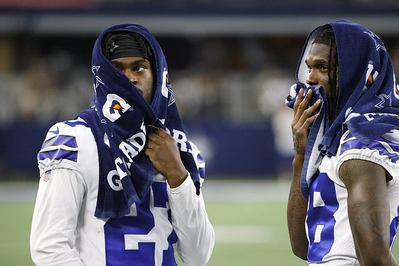 Dallas Cowboys cornerback Trevon Diggs, left, and wide receiver CeeDee Lamb, right, talk on the field after a preseason NFL football game against the Houston Texans in Arlington, Texas, Saturday, Aug. 21, 2021. (AP Photo/Ron Jenkins)