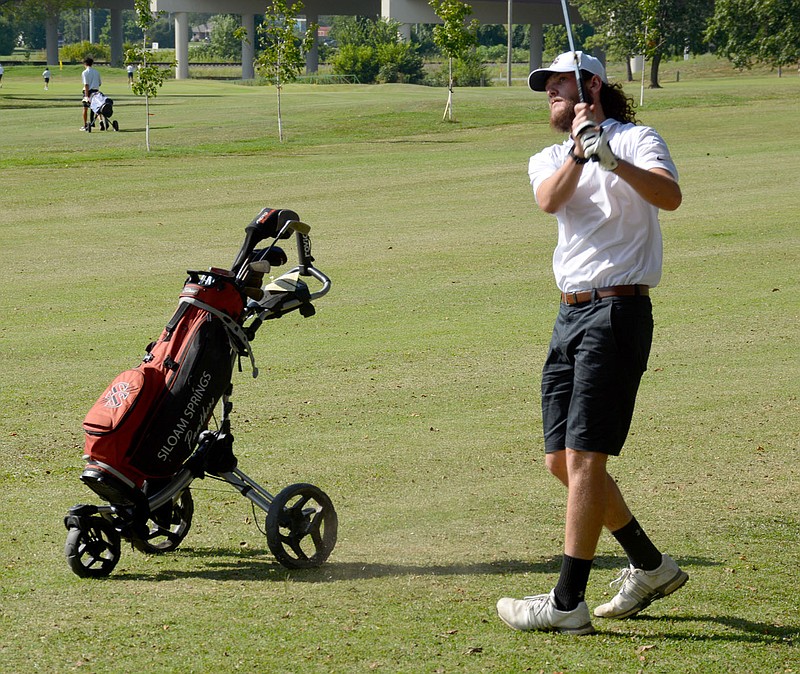Graham Thomas/Herald-Leader
Siloam Springs senior Brayden Fain watches after a shot during Monday's golf match against Greenwood at The Course at Sager's Crossing.