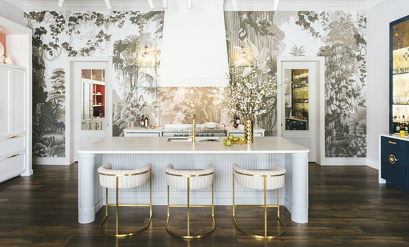 This photo shows designer Jim Dove’s West Palm Beach showroom. De Gournay’s L’Eden wallpaper is placed with an enchanting forest scene, behind a protective sheet of glass. L’Atelier Paris’ range adds another refined French country house element; tailored white cabinetry, sleek white worktop and luxe upholstered chairs keep it all looking modern. (Nicholas Mele/Jim Dove Showroom via AP)