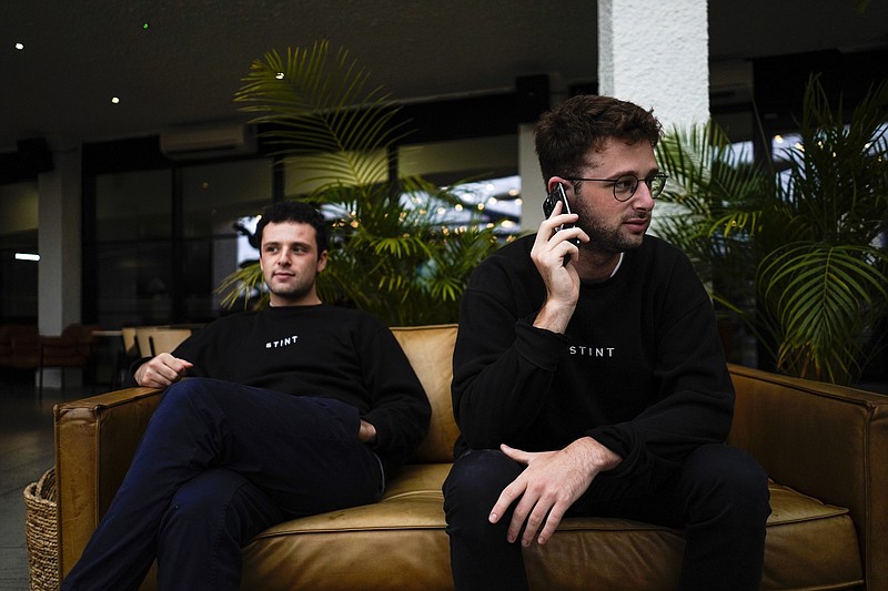 Co-founders of the app Stint, brothers Sam, left, and Sol Schlagman, sit on a couch, at their headquarters in Camden, London, Monday, Aug. 23, 2021. With Britain facing a pandemic and Brexit-induced labor shortage, some apps that recruit gig workers are playing a role in alleviating this shortage, such as Stint. In the U.S., similar apps addressing the pandemic-induced labor shortage are Gig Pro and Instaworks.