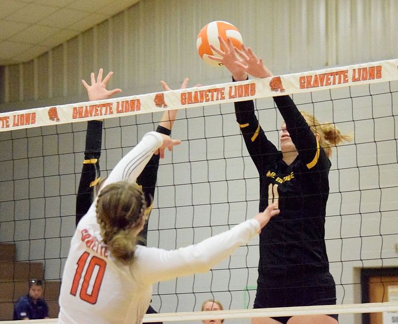 Westside Eagle Observer/MIKE ECKELS

Lady Lion Kelley Elsea (10) hits the ball between the hands of two Lady Tiger players during the second set of the Gravette-Prairie Grove varsity volleyball match in Gravette Thursday night.