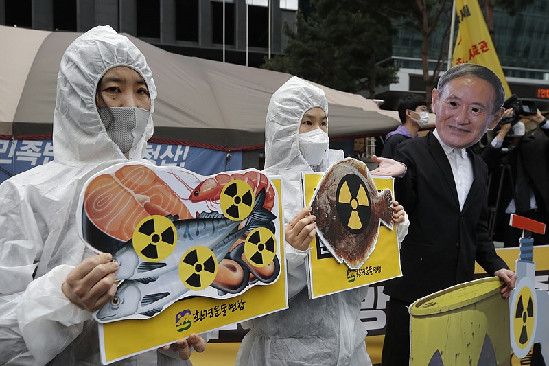 FILE - In this April 13, 2021, file photo, environmental activists wearing a mask of Japanese Prime Minister Yoshihide Suga and protective suits perform to denounce the Japanese government's decision to release treated radioactive Fukushima water, near the Japanese Embassy in Seoul, South Korea. 
(AP Photo/Lee Jin-man, FIle)