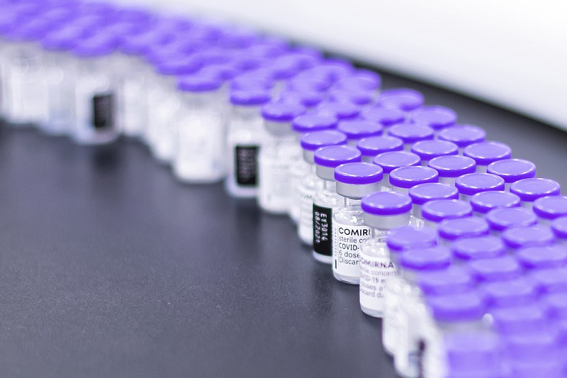 In this March 2021 photo provided by Pfizer, vials of the Pfizer-BioNTech COVID-19 vaccine are prepared for packaging at the company's facility in Puurs, Belgium. On Wednesday, Aug. 25, 2021, the company said it started the application process for U.S. approval of a booster dose of its two-shot COVID-19 vaccine  for people ages 16 and older. (Pfizer via AP)