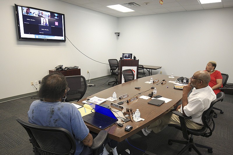 Kenyon Lowe, left, Metropolitan Housing Authority Commission chairman, and commissioners H. Lee Lindsey, middle, and Leta Anthony meet Wednesday Aug. 25, 2021 in Little Rock as other commissioners join the meeting remotely. (Arkansas Democrat-Gazette/Staton Breidenthal)