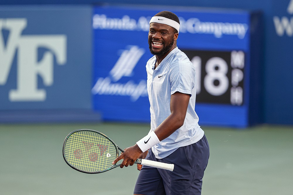 Frances Tiafoe, of the United States, smiles after winning a game in the first set against Thiago Monteiro, of Brazil, at the Winston-Salem Open tennis tournament in Winston-Salem, N.C., Wednesday, Aug. 25, 2021. (AP Photo/Nell Redmond)