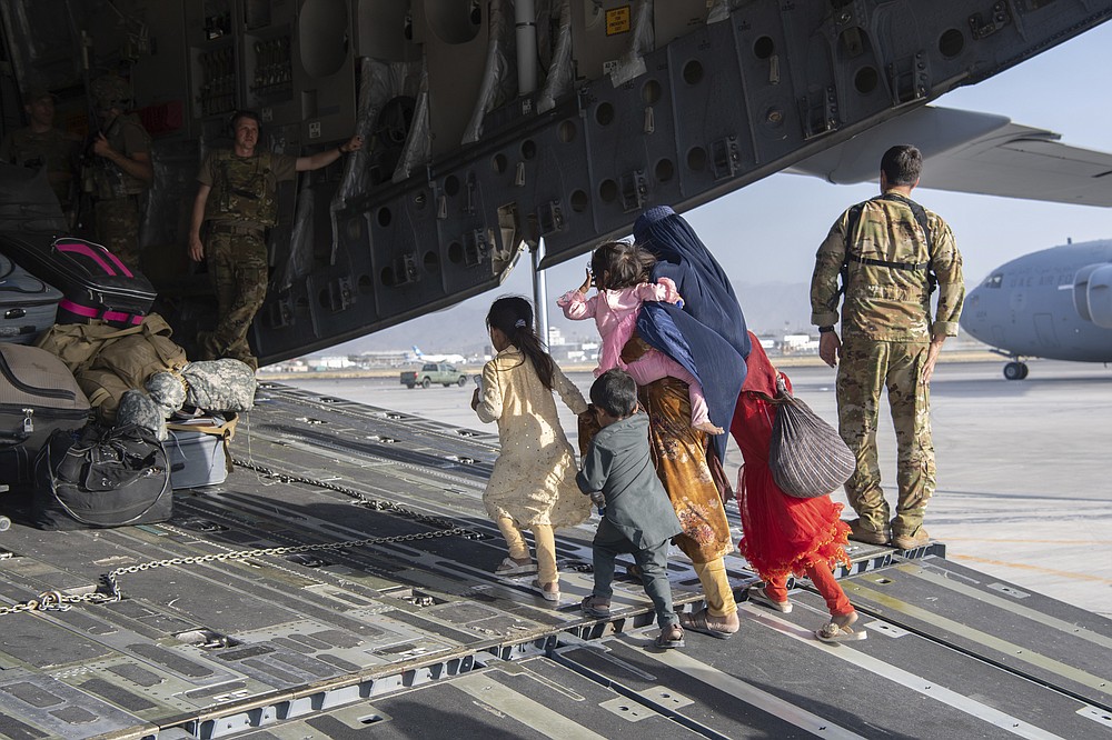 In this image provided by the U.S. Air Force, U.S. Air Force loadmasters and pilots assigned to the 816th Expeditionary Airlift Squadron, load people being evacuated from Afghanistan onto a U.S. Air Force C-17 Globemaster III at Hamid Karzai International Airport in Kabul, Afghanistan, Tuesday, Aug. 24, 2021. (Master Sgt. Donald R. Allen/U.S. Air Force via AP)