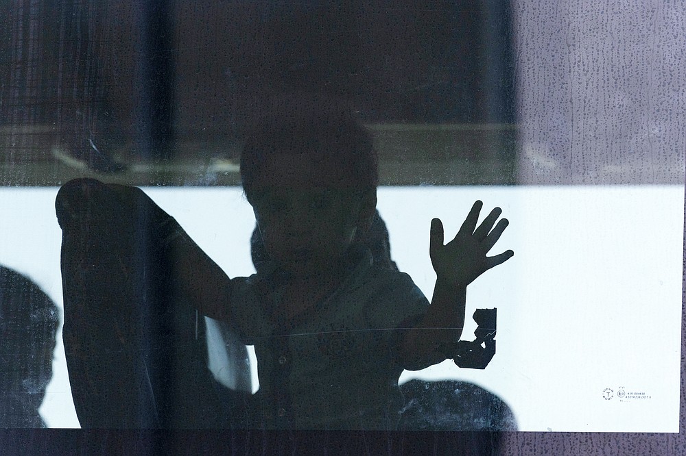 Children accompanied by their families evacuated from Kabul, Afghanistan, sit inside a bus after they arrived at Washington Dulles International Airport, in Chantilly, Va., on Wednesday, Aug. 25, 2021. (AP Photo/Jose Luis Magana)