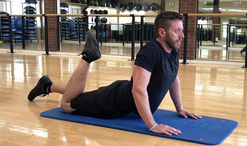 Josh Holt, fitness director of Little Rock Racquet Club, demonstrates the Cobra With Quad Stretch for Matt Parrott's Master Class (Arkansas Democrat-Gazette/Celia Storey)