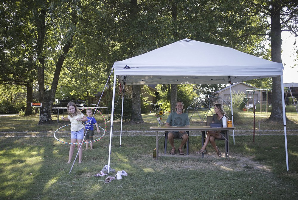 Caleb Schoeppe (center) and his partner Sydney Sloan (center right) wait for customers as kids Monroe Schoeppe, 10, (from left) and Oxford Schoeppe, 6, play, Friday, August 27, 2021 at Sacred Hollow Farm in Lowell. The pandemic forced Caleb Schoeppe and his partner Sydney Sloan to take a hard look at their lives and they decided they didn't really like what they saw - so Caleb quit his corporate job, Sydney stopped styling hair, and they opened up a u-pick wildflowers business on their acreage. Check out nwaonline.com/210830Daily/ for today's photo gallery. 
(NWA Democrat-Gazette/Charlie Kaijo)