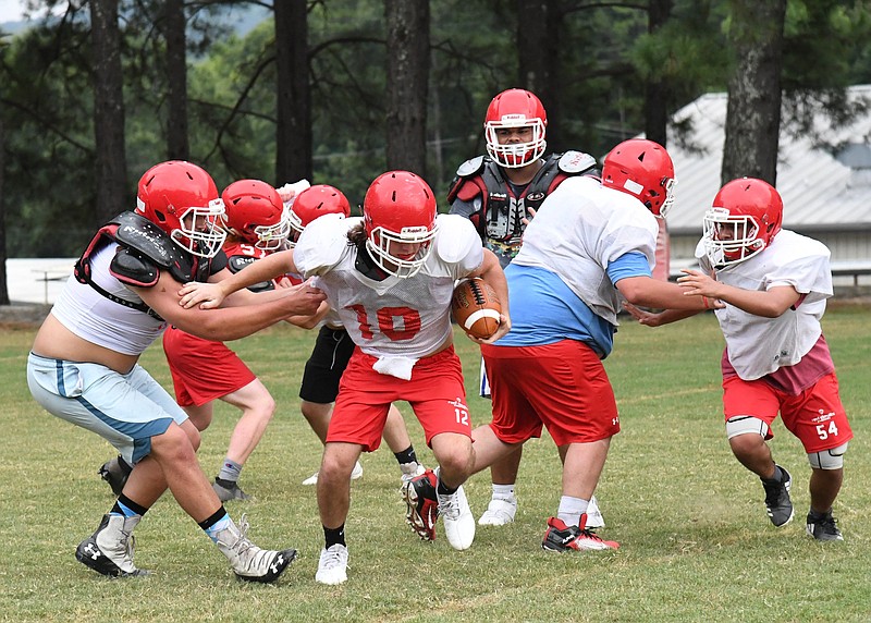 Members of the Mountain Pine Red Devils football team run through drills in preparation for tonight's season opener against Episcopal Collegiate. - Photo by Tanner Newton of The Sentinel-Record