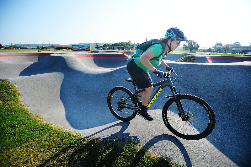 Jennifer Smay of Fayetteville rides her bicycle Friday on the pump track at the Runway Bike Park in Springdale. The park is the planned site for the USA Pump Track Championship Series Final Sept. 4 with racing for six age groups from ages 7 years to masters. 
(NWA Democrat-Gazette/Andy Shupe)