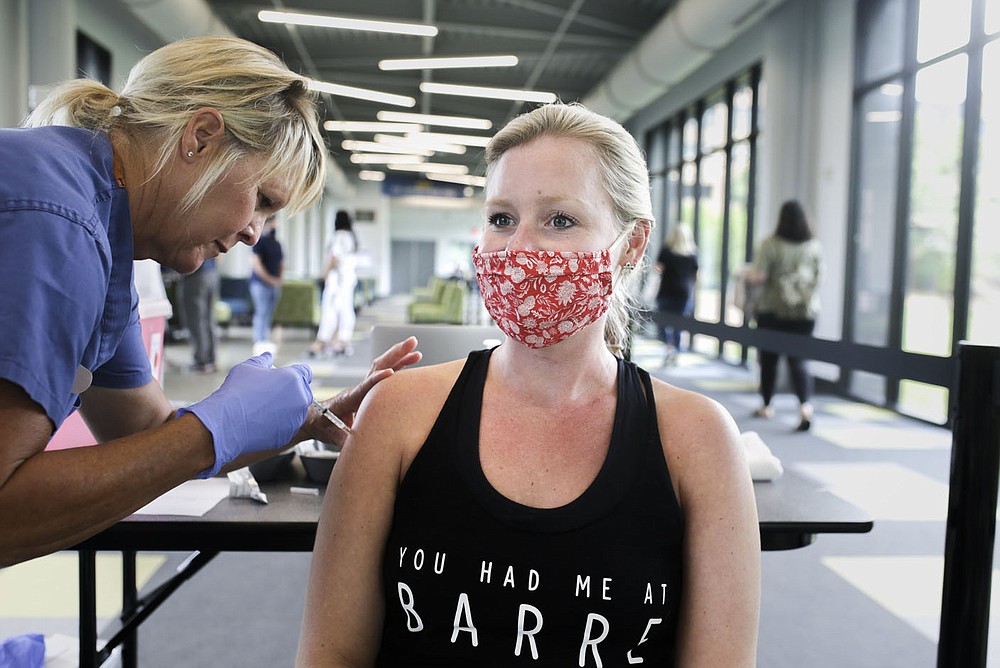 Nurse Velvet Shoults (from left) administers a covid-19 vaccine booster to Morgan Riddles, Friday, August 27, 2021 at the J.B. Hunt headquarters in Lowell. Miss Arkansas USA Stephanie Barber appeared at a vaccine clinic hosted by the Northwest Arkansas Council to encourage vaccinations and take photos with participants. Check out nwaonline.com/210828Daily/ for today's photo gallery.
(NWA Democrat-Gazette/Charlie Kaijo)