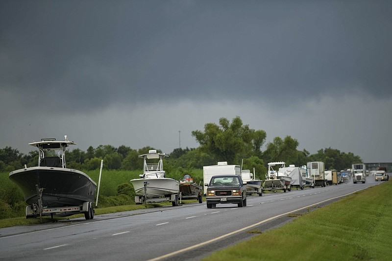 Boats, trailers and RVs line Louisiana Highway 46 after owners moved them to be inside the levee protection zone before  Hurricane Ida makes landfall in St. Bernard Parish, La., Saturday, Aug. 28, 2021.  Hurricane Ida looks an awful lot like Hurricane Katrina, bearing down on the same part of Louisiana on the same calendar date. But hurricane experts say there are differences in the two storms 16 years apart that may prove key and may make Ida nastier in some ways but less dangerous in others..(AP Photo/Matthew Hinton)