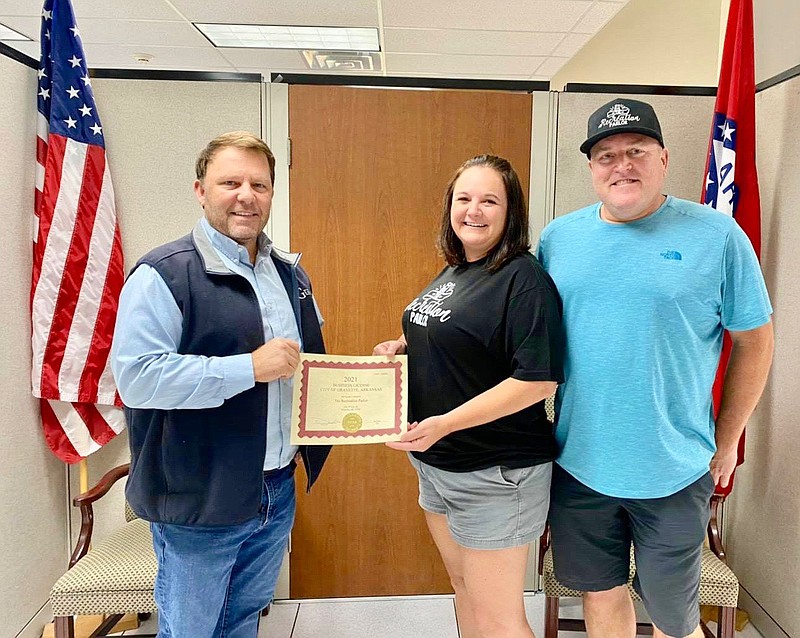 Submitted Photo
Gravette mayor Kurt Maddox presents a business license to Sylvia and Travis Norris, owners of Gravette's newest business, the Recreation Parlor. The Recreation Parlor opened for business Saturday in the building just north of the present City Hall.